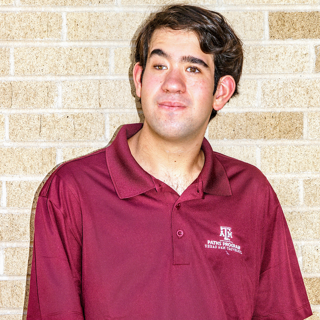 Oliver Kaneb, a young person with short brown hair wearing a red polo shirt.